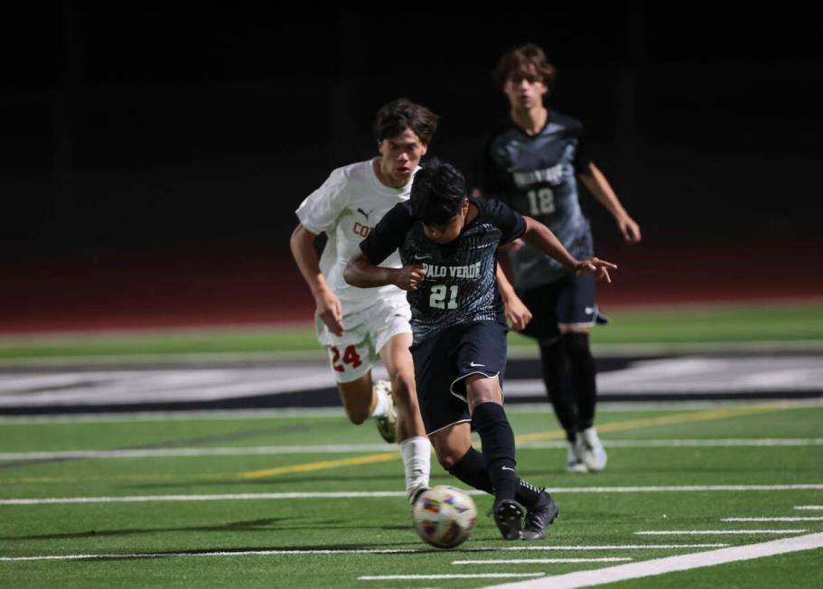 Palo Verde's Eric Rojas (21) runs with the ball under pressure from Coronado during a soccer ga ...