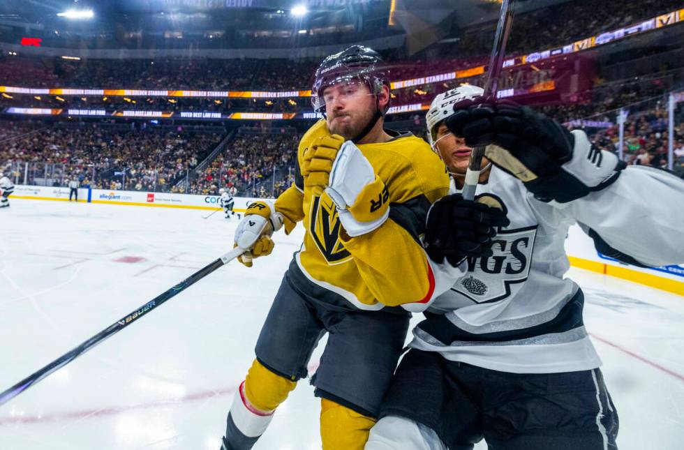 Golden Knights defenseman Zach Whitecloud (2) checks Los Angeles Kings left wing Trevor Moore ( ...