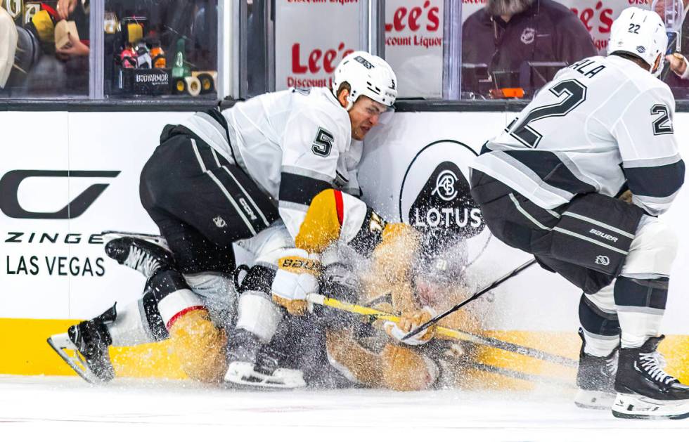 Golden Knights center Brett Howden (21) still fights for the puck while down on the ice with Lo ...