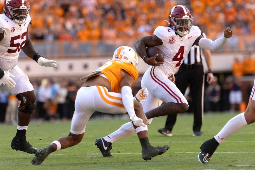 Alabama quarterback Jalen Milroe (4) runs for yardage as he's chsed byTennessee defensive back ...