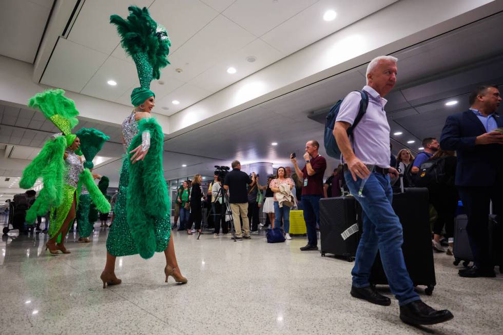 A traveller walks by as showgirls perform to “Viva Las Vegas” by Elvis Presley fo ...