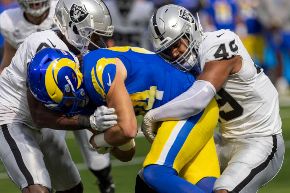 Raiders defensive end Charles Snowden (49) and cornerback Jakorian Bennett (0) tackle Los Angel ...