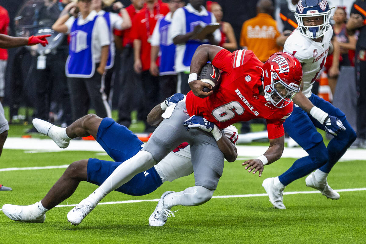 UNLV quarterback Hajj-Malik Williams (6) looks to the end zone as Fresno State Bulldogs defensi ...