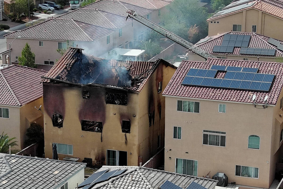 The remains of a charred house are seen after an early morning fire at 8332 Langhorne Creek Str ...