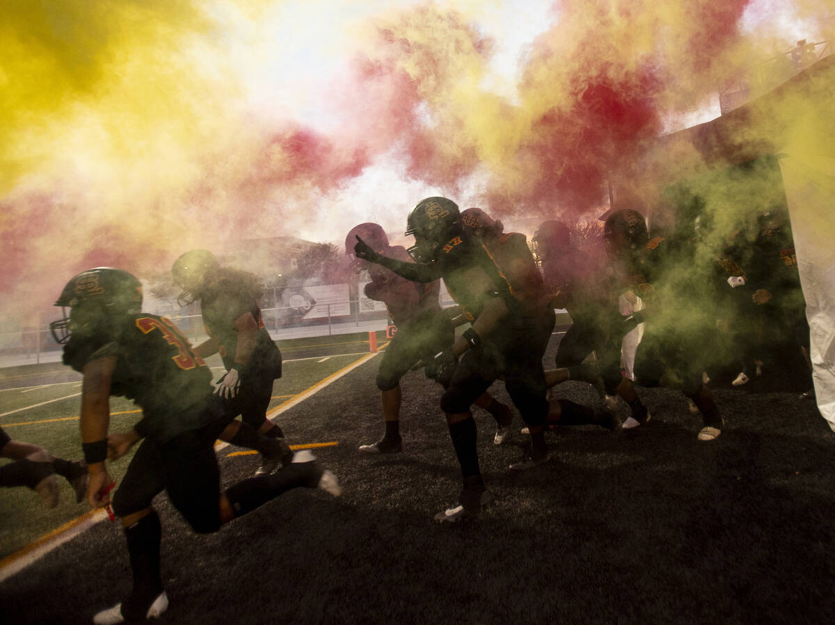 Losee players run onto the field before the high school 4A Desert League title football game ag ...