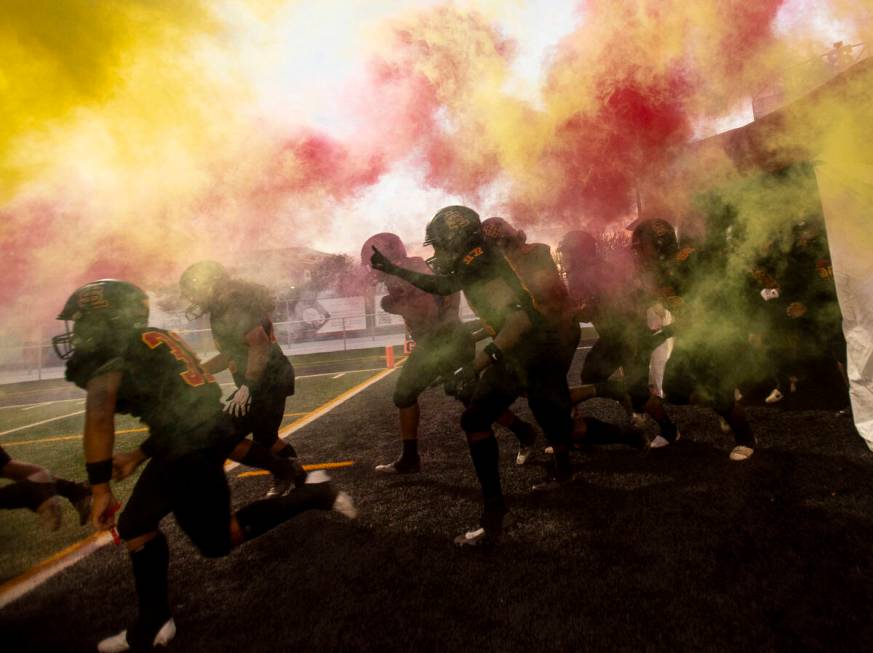 Losee players run onto the field before the high school 4A Desert League title football game ag ...