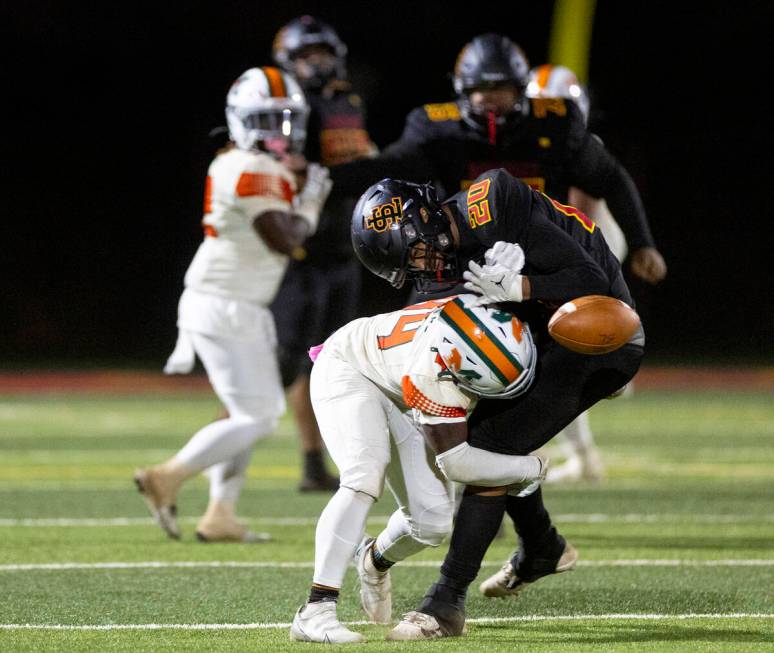 Mojave sophomore Zechariah Johnson (44) delivers a hit to Losee sophomore Coen Daniel (20) duri ...