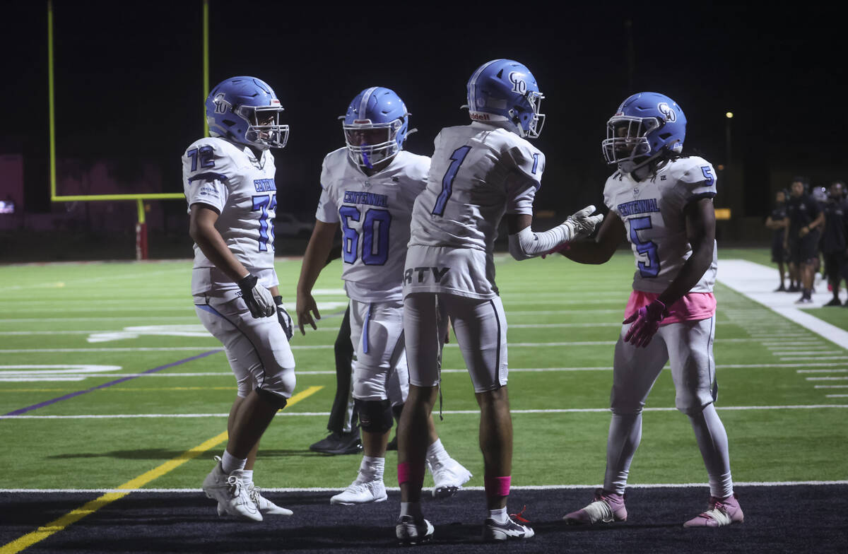 Centennial running back Khy Harris (5) celebrates his touchdown with Jayden Thomas (1) during a ...