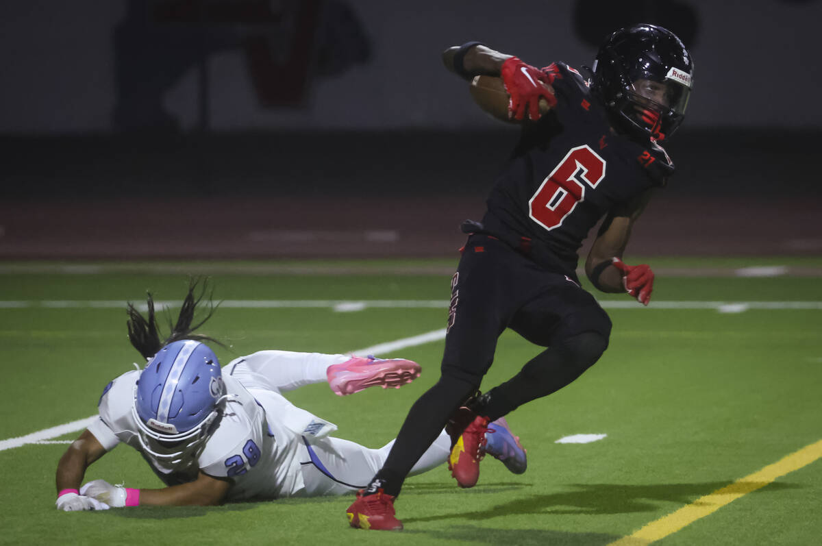 Las Vegas' Mychael Walker (6) runs the ball against Centennial's Hayden Contreras (28) during a ...