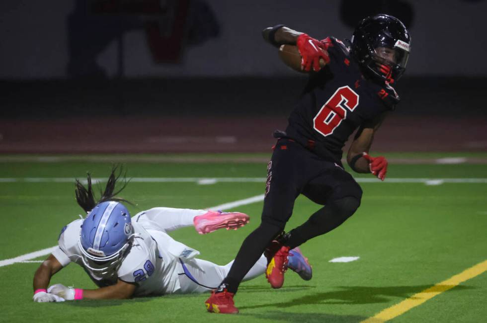 Las Vegas' Mychael Walker (6) runs the ball against Centennial's Hayden Contreras (28) during a ...