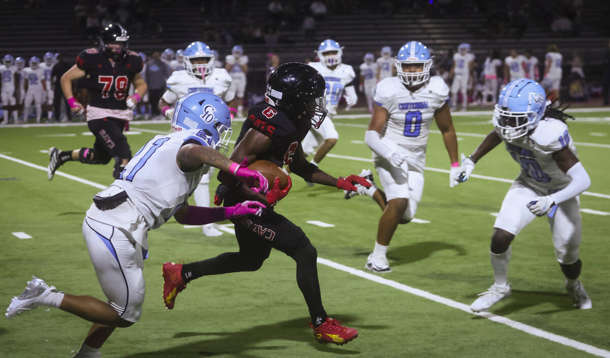 Las Vegas' Mychael Walker (6) runs the ball under pressure from Centennial's Domonique Vaughn ( ...