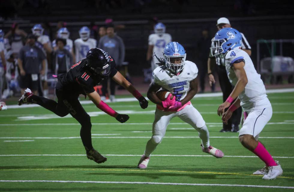 Centennial running back Khy Harris (5) runs the ball under pressure from Las Vegas defensive en ...