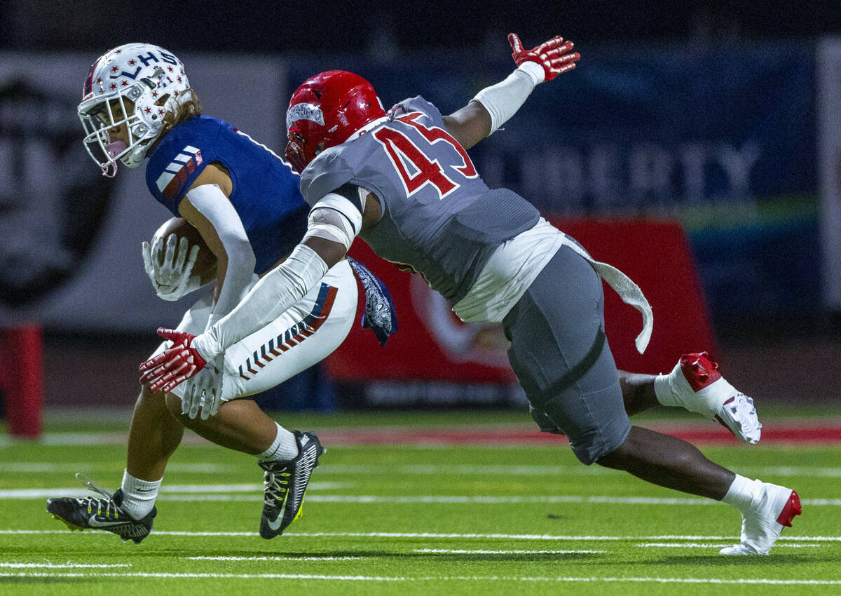 Liberty running back Ezra Sanelivi (1) looks for more yards as Arbor View defensive lineman Don ...