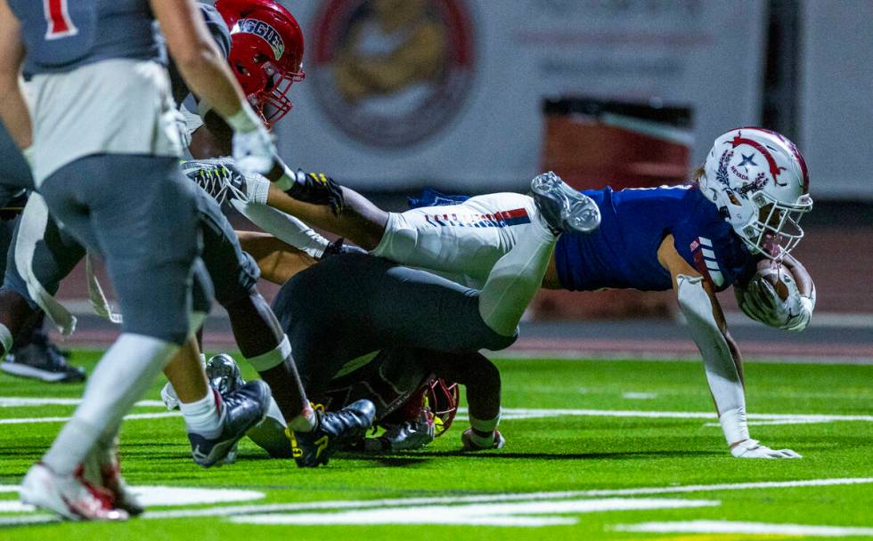 Liberty running back Ezra Sanelivi (1) extends for a few more yards as Arbor View safety Damien ...