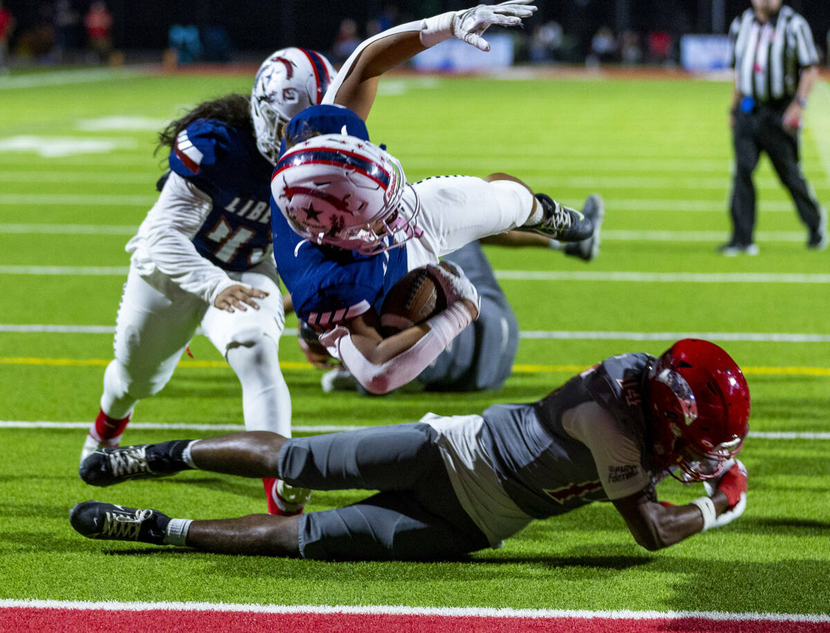 Liberty running back Ezra Sanelivi (1) flies in for a touchdown as Arbor View cornerback JT Col ...