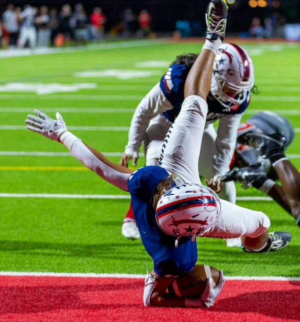 Liberty running back Ezra Sanelivi (1) flies in for a touchdown as Arbor View cornerback JT Col ...