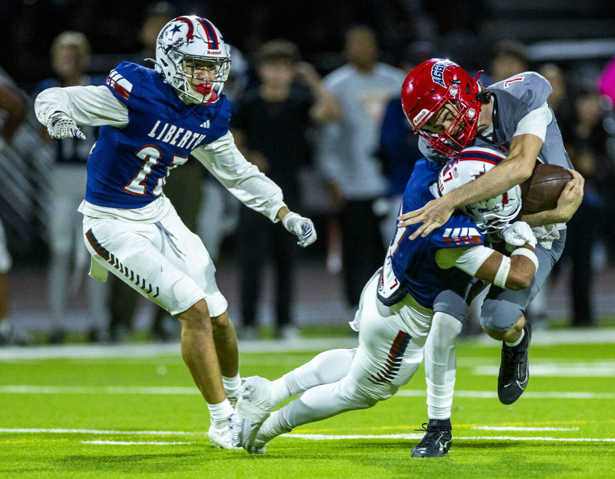 Arbor View quarterback Thaddeus Thatcher (7) takes on Liberty defensive back Gravis Lopez (7) f ...