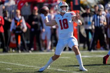 Wisconsin quarterback Braedyn Locke passes the ball during the first half of an NCAA college fo ...