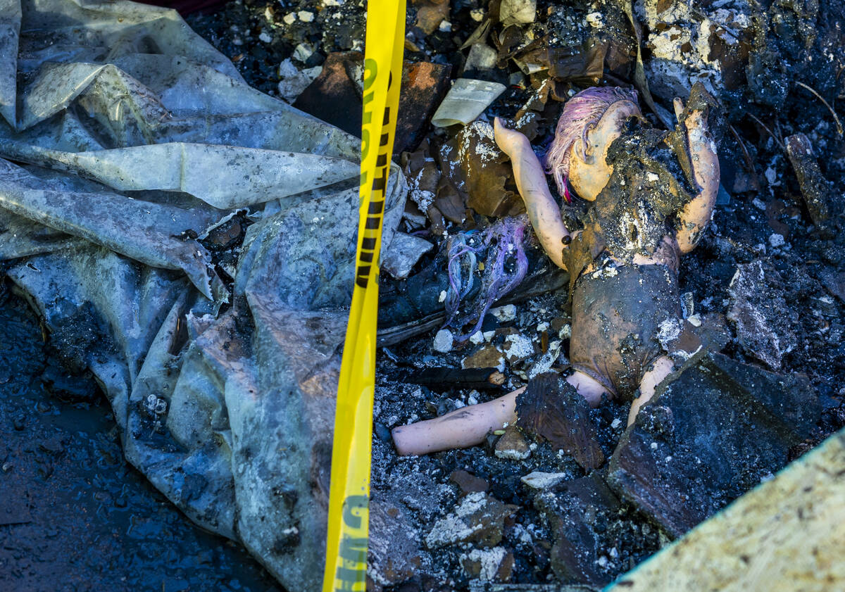 A baby doll lies in the debris about the exterior of fatal house fire at 8332 Langhorne Creek S ...