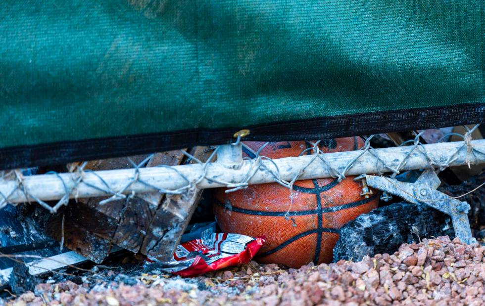 A basketball is wedged about emergency fencing around the exterior of fatal house fire at 8332 ...