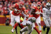 Kansas City Chiefs tight end Travis Kelce (87) pushes aside Las Vegas Raiders cornerback Nate H ...