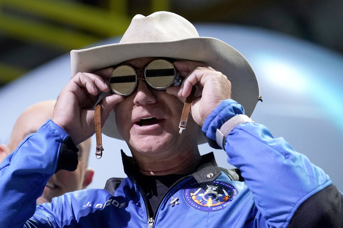 FILE - Jeff Bezos, founder of Amazon and space tourism company Blue Origin, puts goggles over h ...