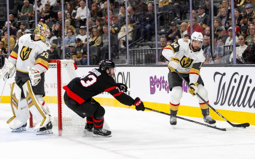 Golden Knights defenseman Nicolas Hague (14) takes the puck behind the net during the second pe ...