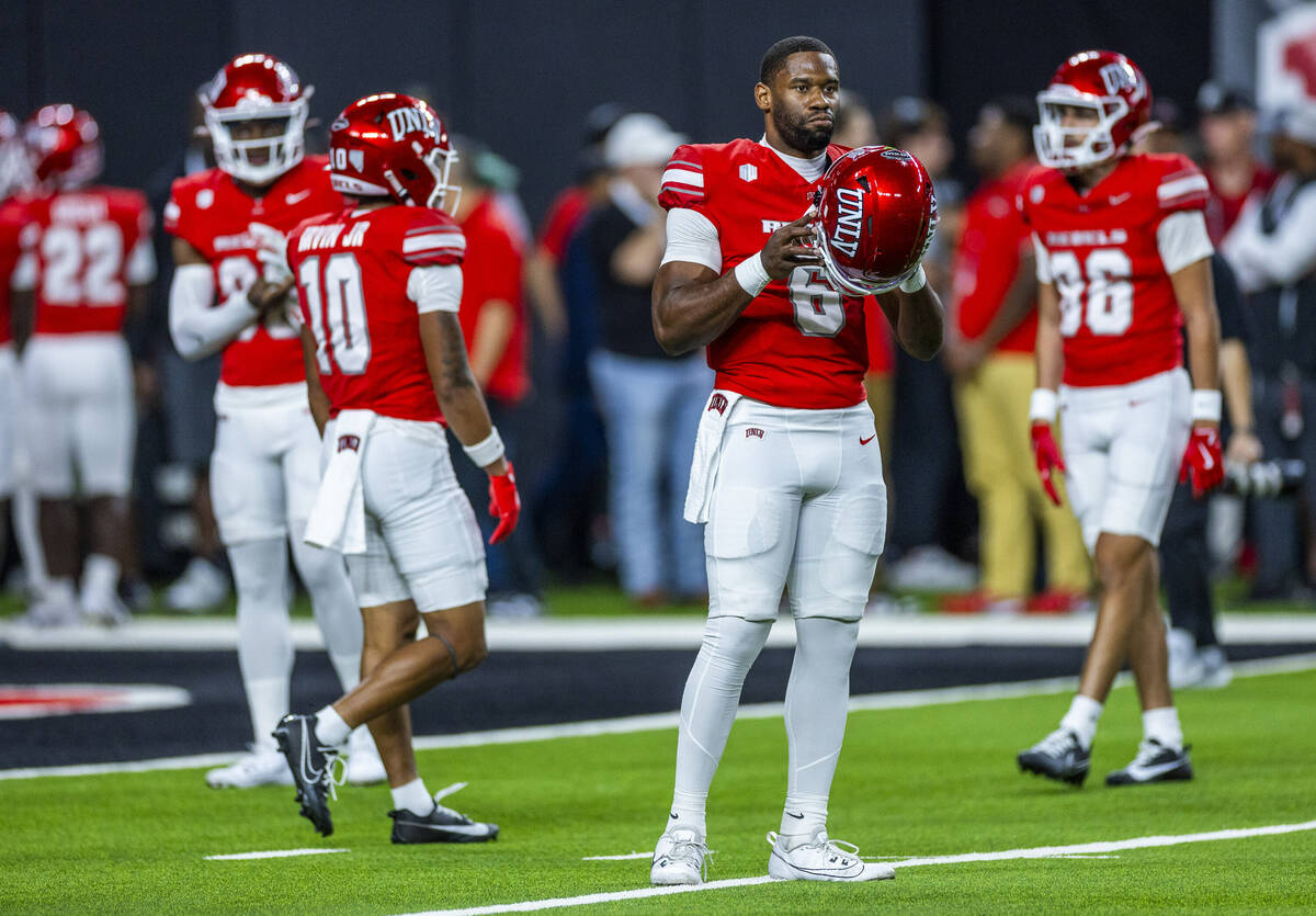 UNLV quarterback Hajj-Malik Williams (6) looks to Boise State players during warm ups of their ...