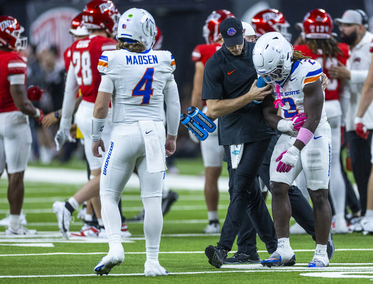 Boise State Broncos running back Ashton Jeanty (2) holds an injured arm as he's escorted off th ...