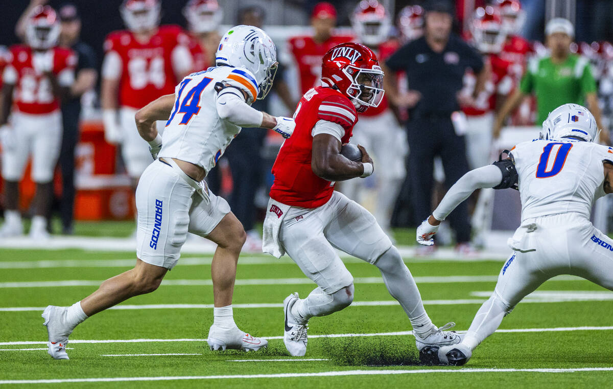 UNLV quarterback Hajj-Malik Williams (6) cuts past Boise State Broncos safety Ty Benefield (0) ...