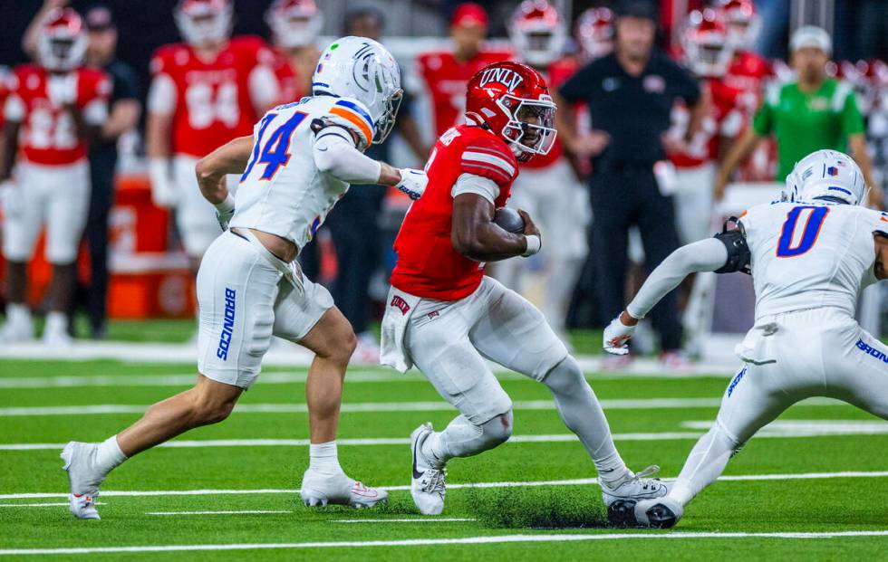 UNLV quarterback Hajj-Malik Williams (6) cuts past Boise State Broncos safety Ty Benefield (0) ...