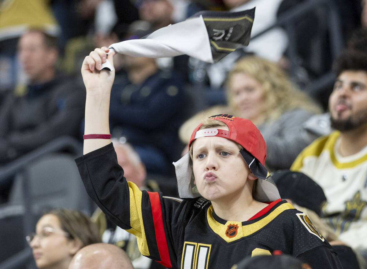 A young Golden Knights fan cheers after a goal is scored during the first period of the NHL hoc ...