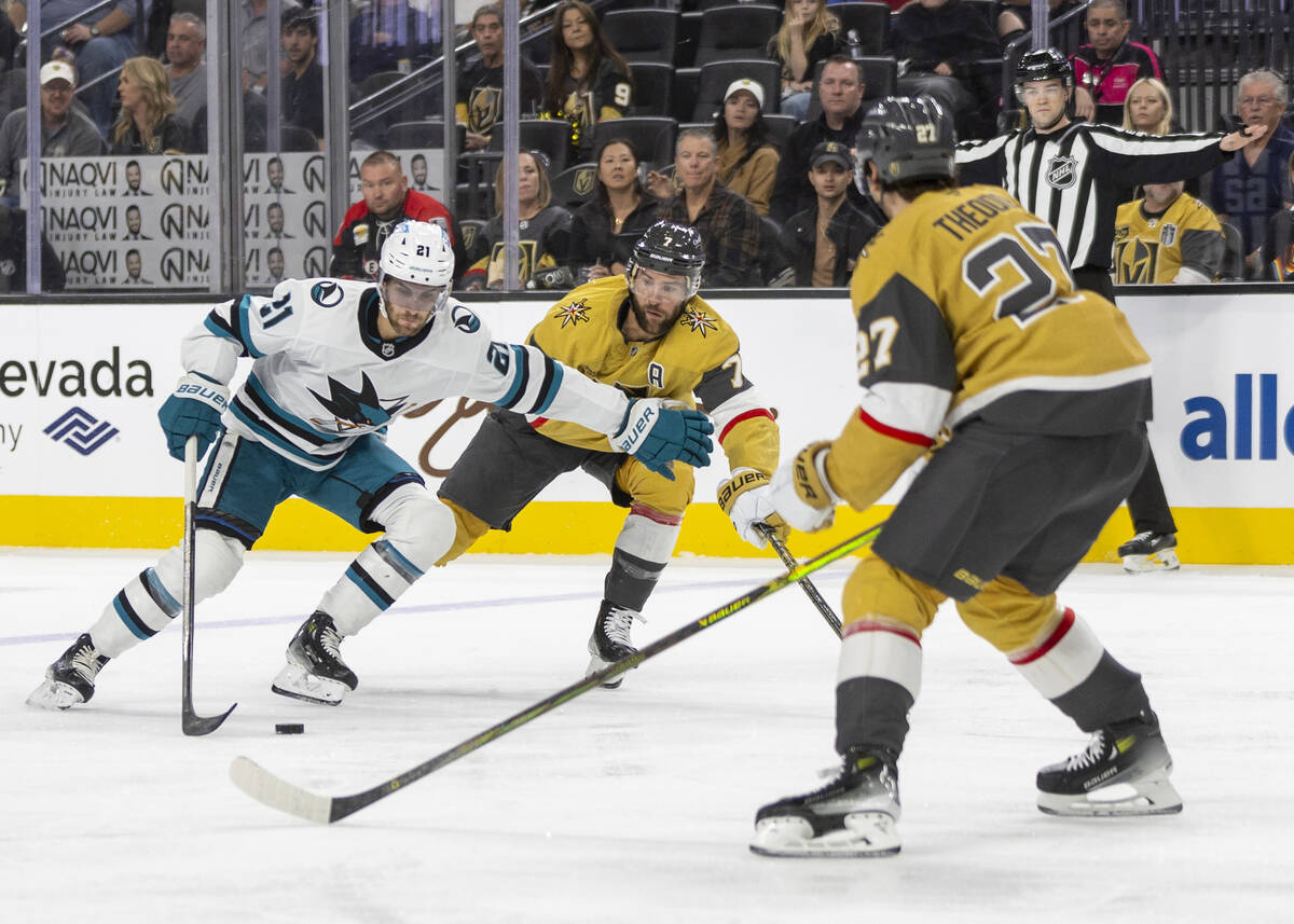 San Jose Sharks center Alexander Wennberg (21) keeps the puck from Golden Knights defenseman Al ...