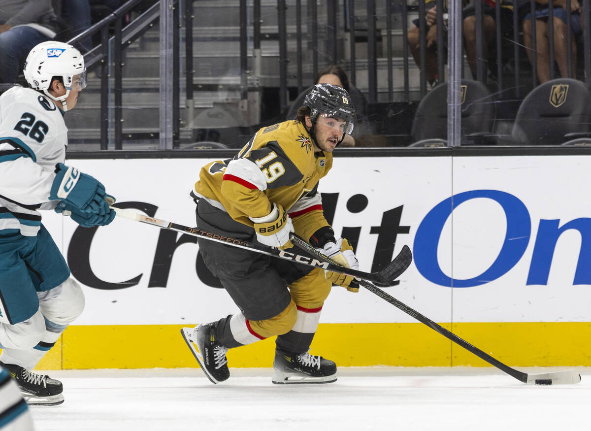 Golden Knights center Brendan Brisson (19) keeps the puck away from San Jose Sharks defenseman ...