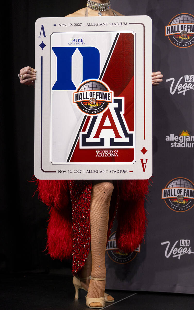 A showgirl holds a playing card revealing one of the scheduled games during the announcement of ...