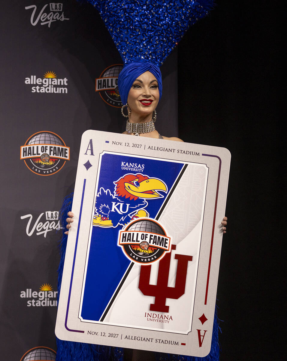 A showgirl holds a playing card revealing one of the scheduled games during the announcement of ...