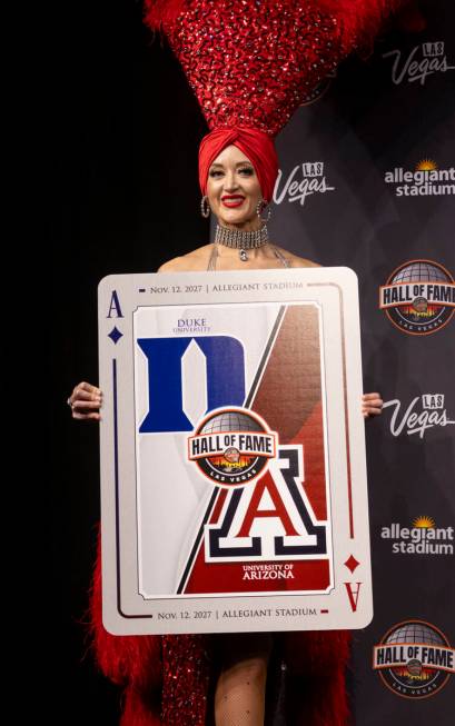 A showgirl holds a playing card revealing one of the scheduled games during the announcement of ...