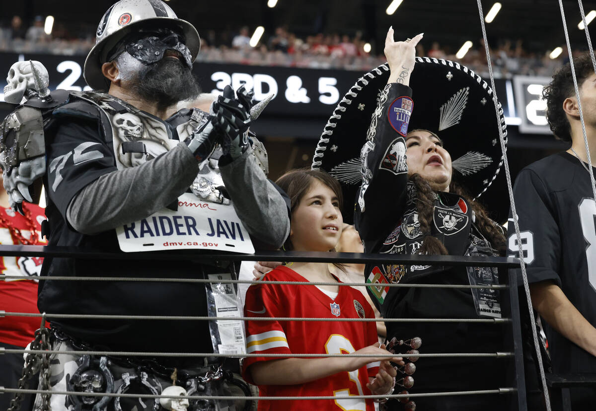 Kansas City Chiefs fan Sarah Greenblatt, 10, stands between Raiders fans as she watches an NFL ...