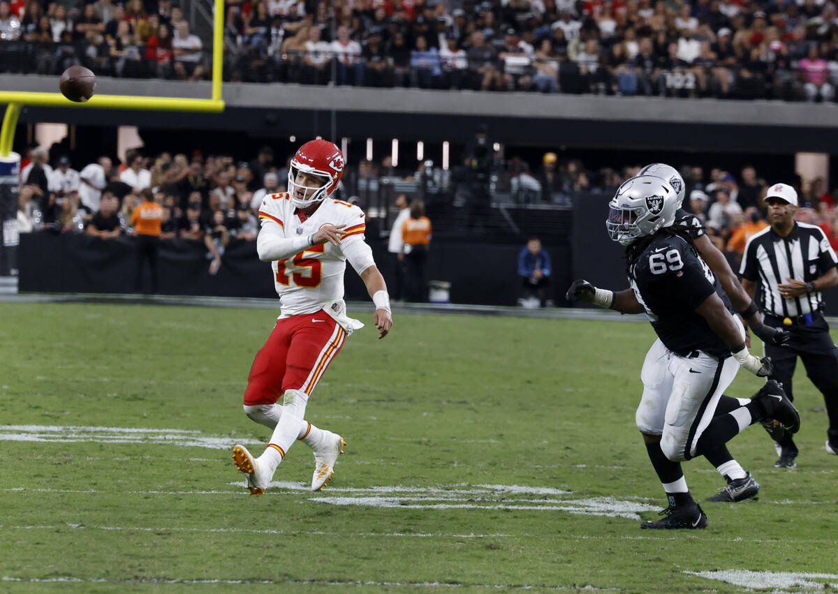 Kansas City Chiefs quarterback Patrick Mahomes (15) releases the ball as he is chased by Raider ...