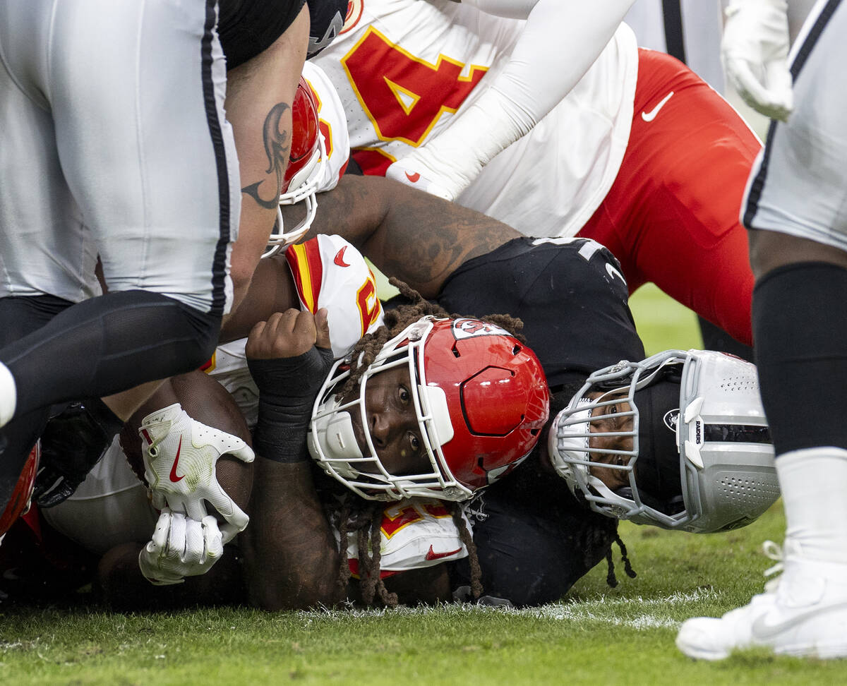 Raiders defensive tackle John Jenkins (95) holds on to Kansas City Chiefs running back Kareem H ...