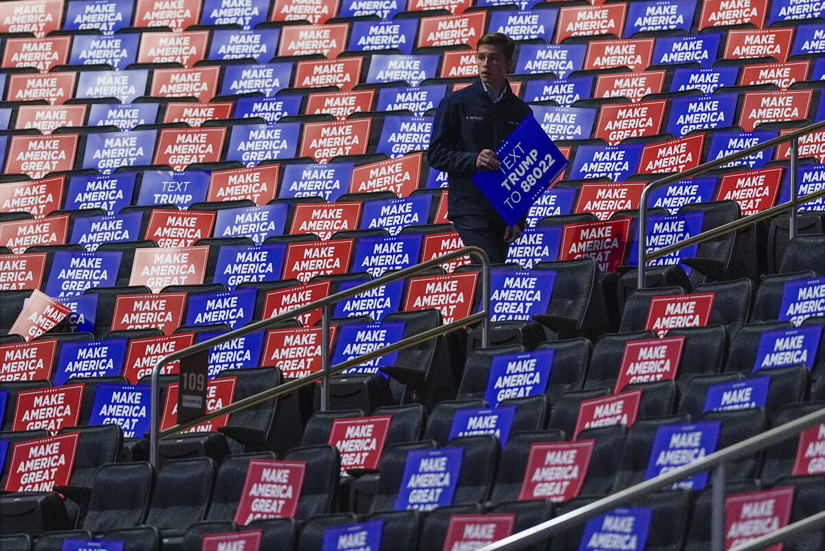 A worker places signs in seats before Republican presidential nominee former President Donald T ...