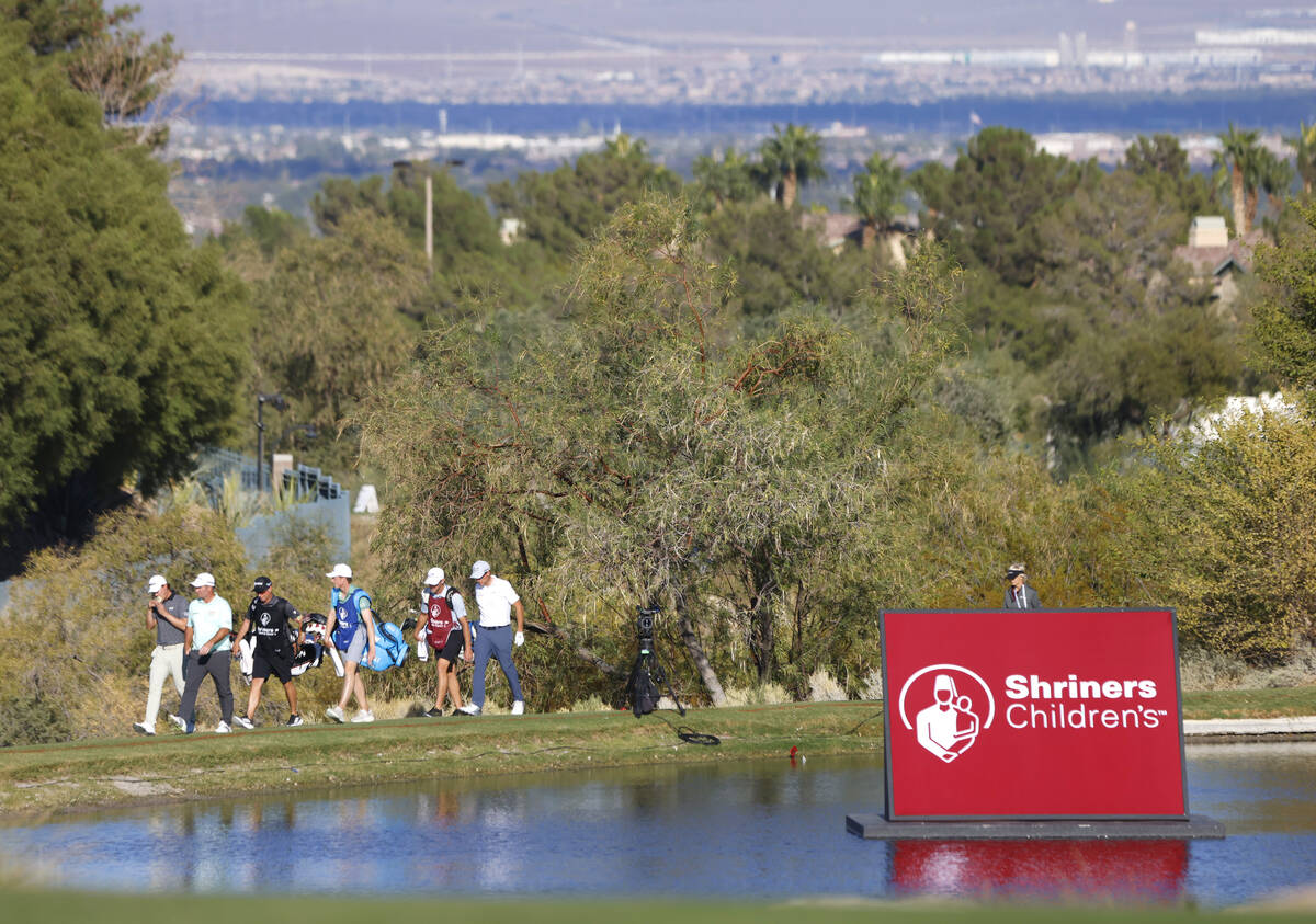 Players and their caddies walk toward green No.18 during the third round of the Shriners Childr ...