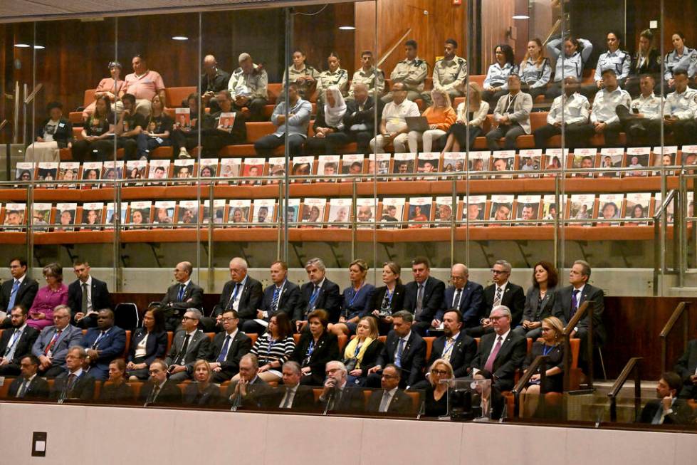 Posters with photos of Israeli hostages set in empty chairs are seen at the opening of the 25th ...