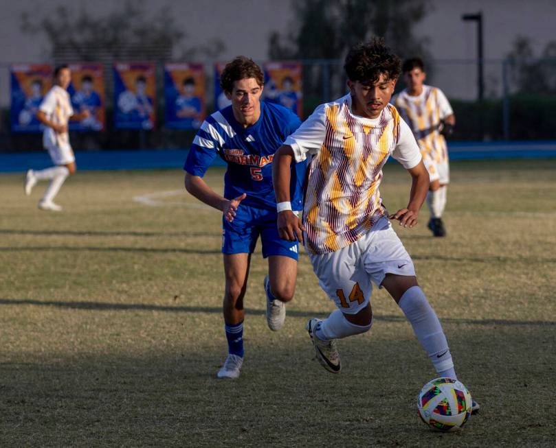 Eldorado sophomore Angel Lopez (14) keeps the ball from Bishop Gorman midfielder Benjamin Carpe ...