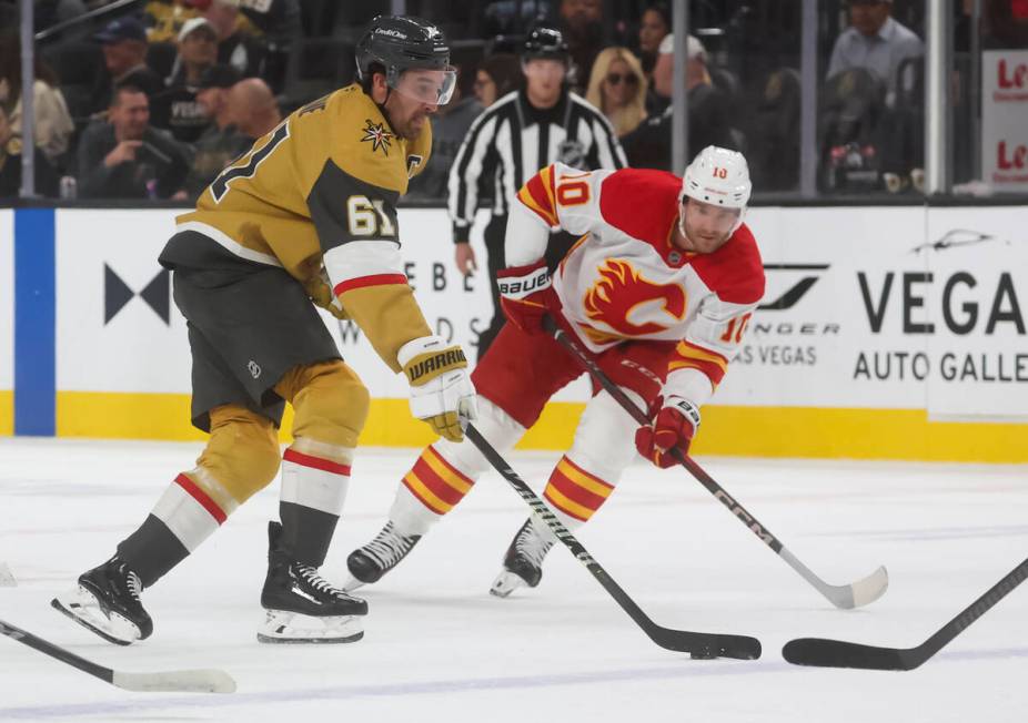 Golden Knights right wing Mark Stone (61) skates with the puck under pressure from Calgary Flam ...