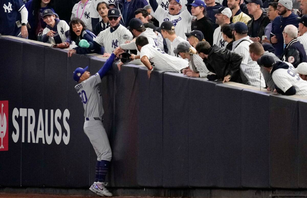 Fans interfere with a foul ball caught by Los Angeles Dodgers right fielder Mookie Betts during ...