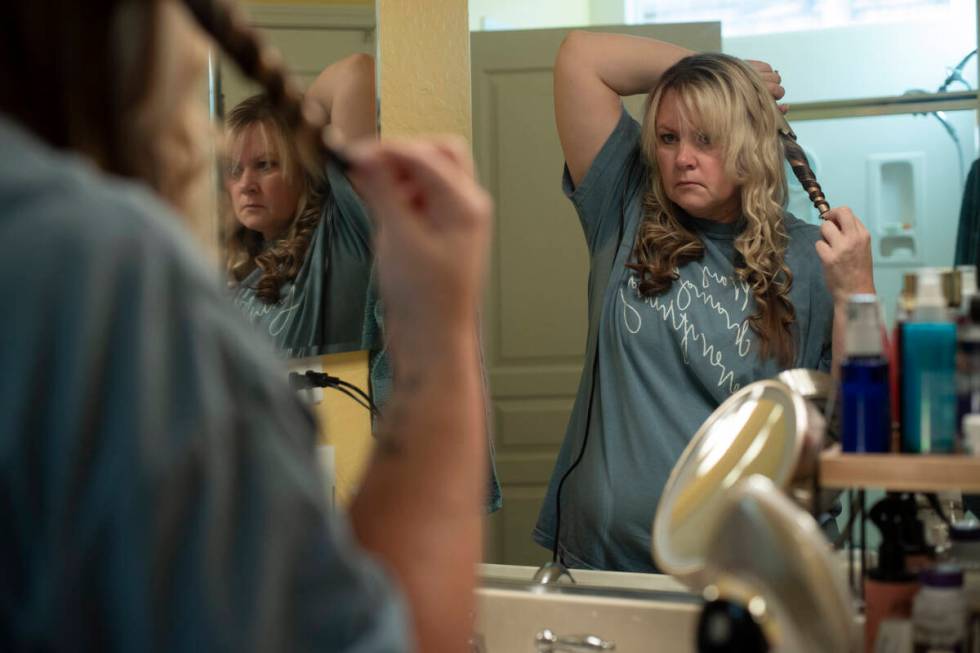 Cari-Ann Burgess, interim Registrar of Voters for Washoe County, Nev., curls her hair before ch ...