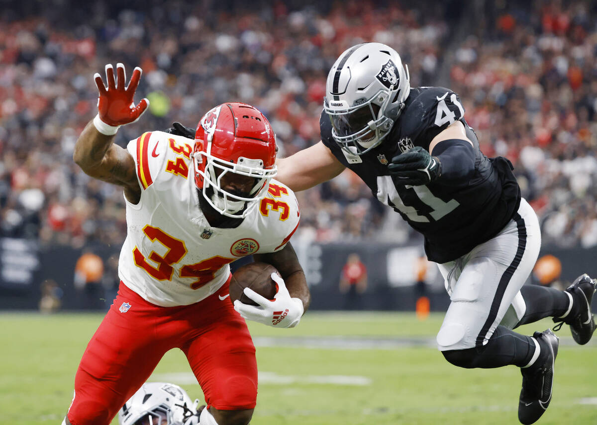 Kansas City Chiefs running back Samaje Perine (34) stretches for extra yards as Raiders linebac ...