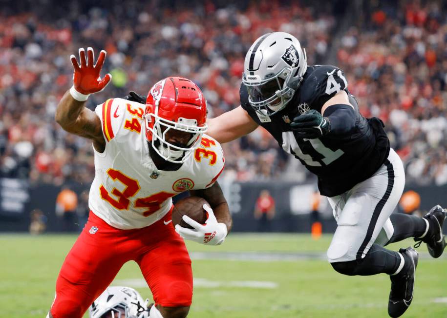 Kansas City Chiefs running back Samaje Perine (34) stretches for extra yards as Raiders linebac ...