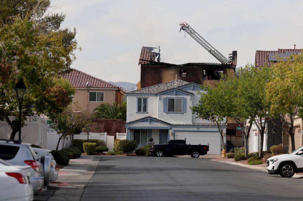 The remains of a charred house are seen after an early morning fire at 8332 Langhorne Creek Str ...